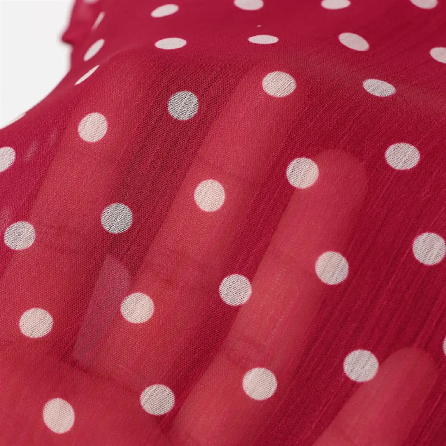 Hand behind fabric transparency shot, crinkled chiffon texture, white dot printing permeability, lightweight gauzy material