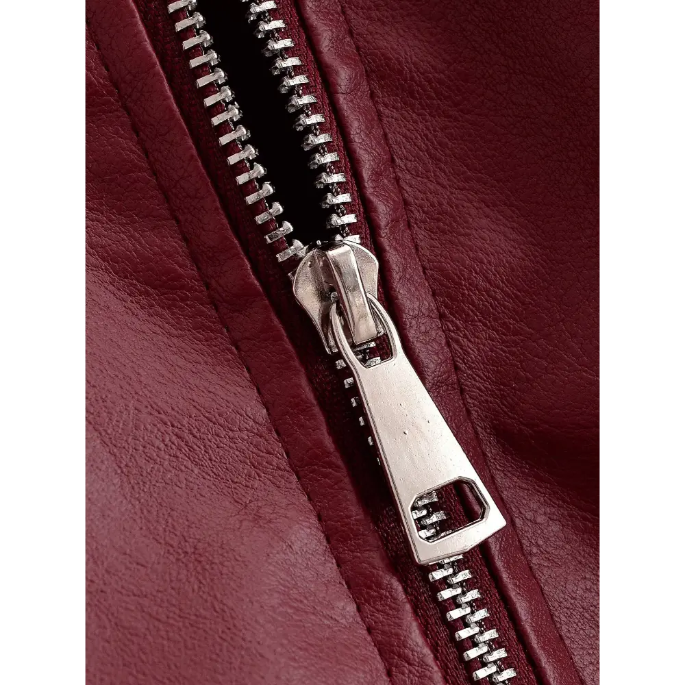Close-up of silver zipper teeth and faux leather grain