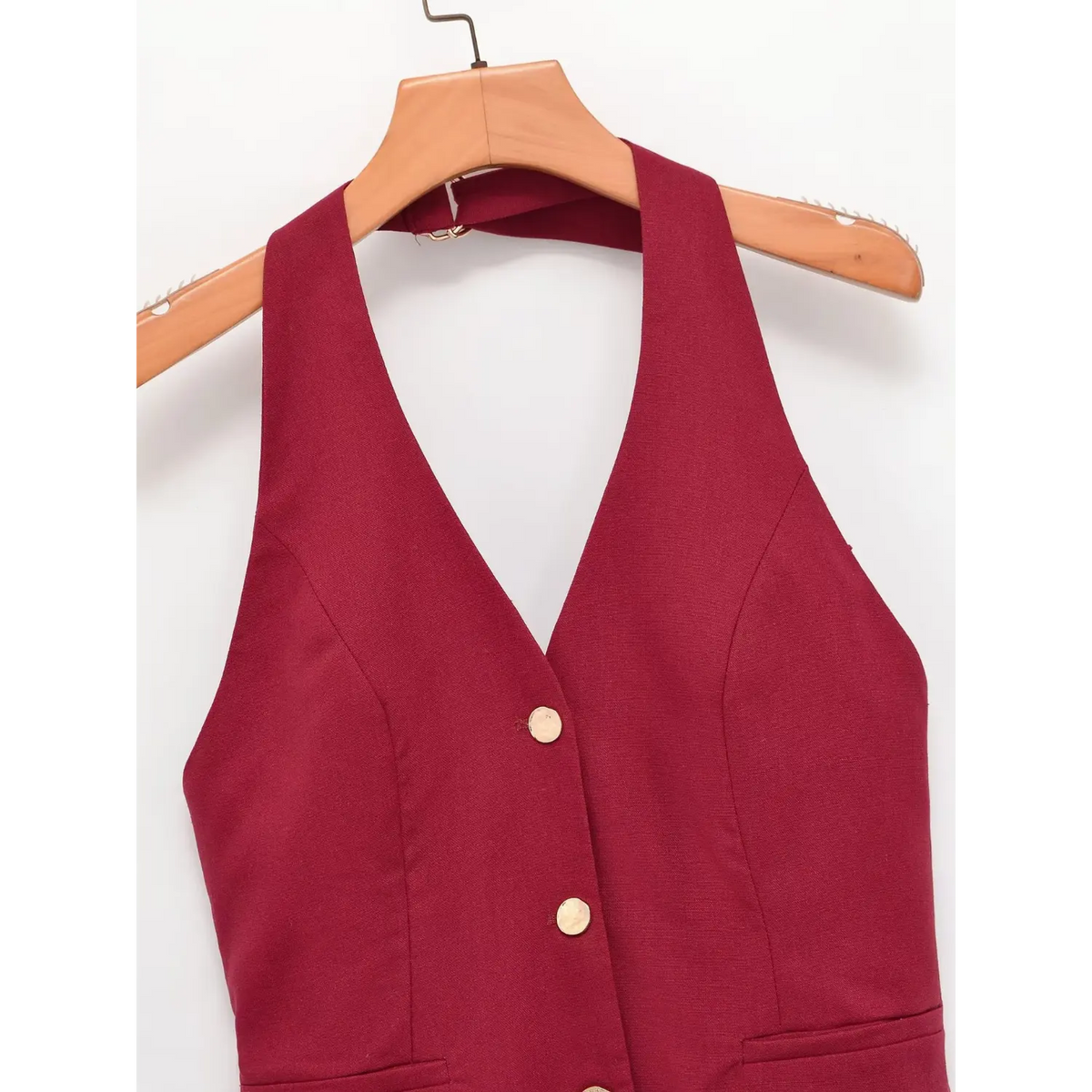 Burgundy halter vest hanging on wooden hanger