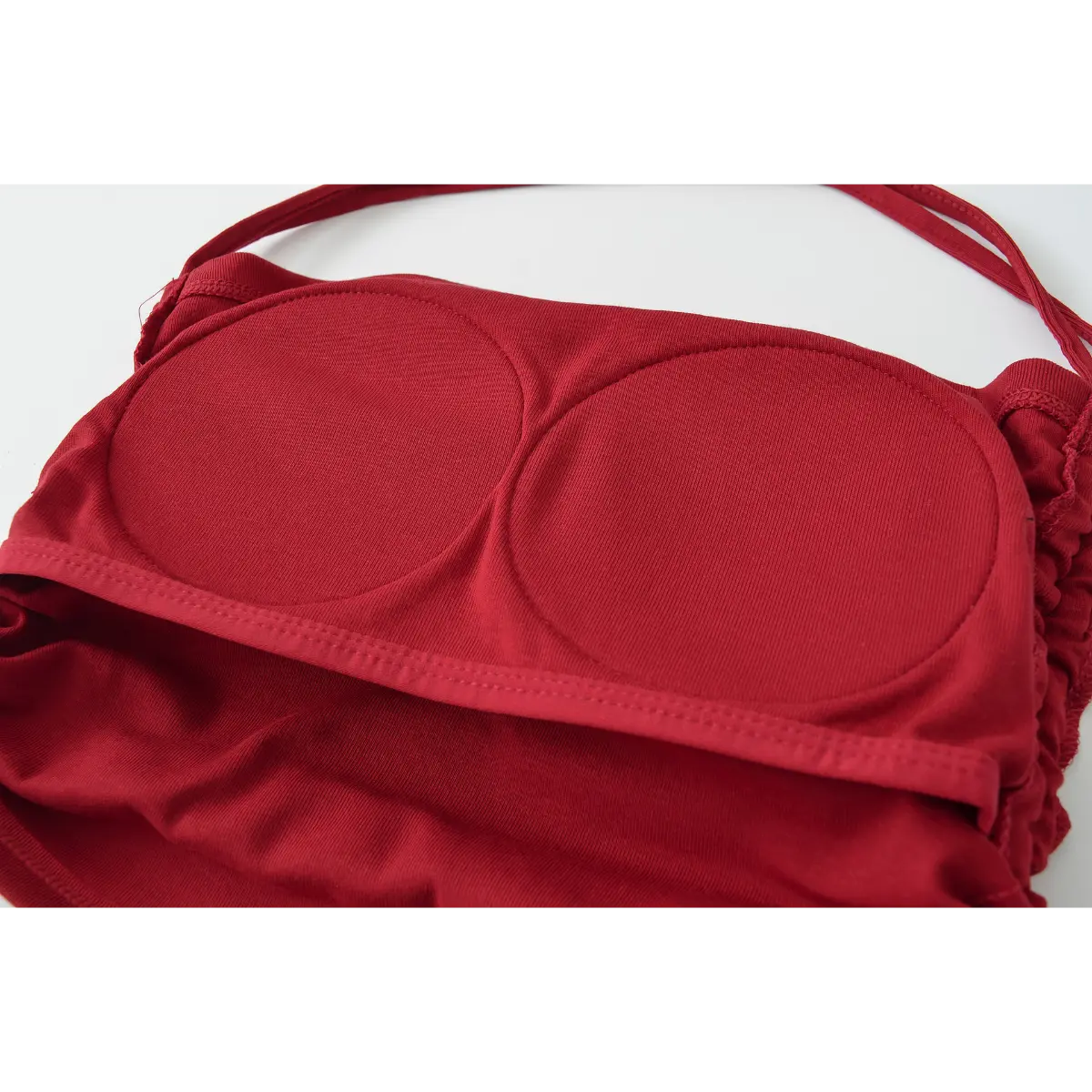 Close-up of the built-in bra cups, showing their smooth, stretchy construction inside the burgundy halter top.