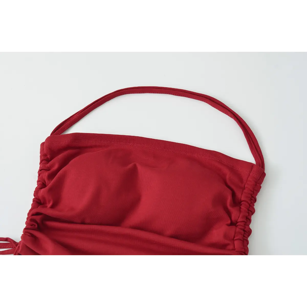 Full view of the burgundy halter top, highlighting the halter neckline, side drawstrings, and cropped silhouette.