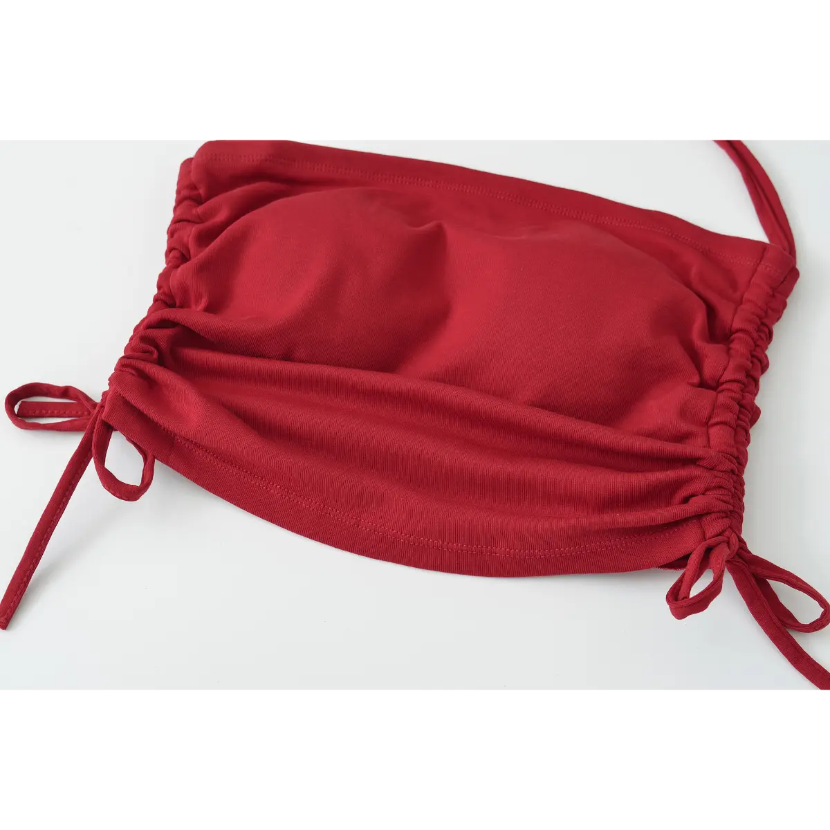 Full view of the cropped hem and drawstring ties, showing the gathered effect on the burgundy halter top.