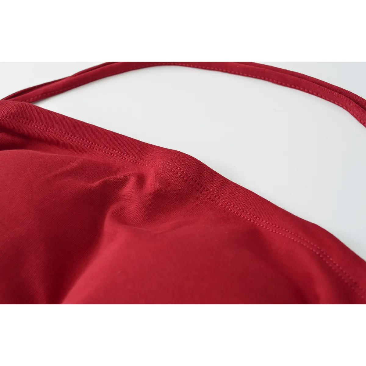 Close-up of the wide halter strap and double-stitched top edge on the burgundy halter top.