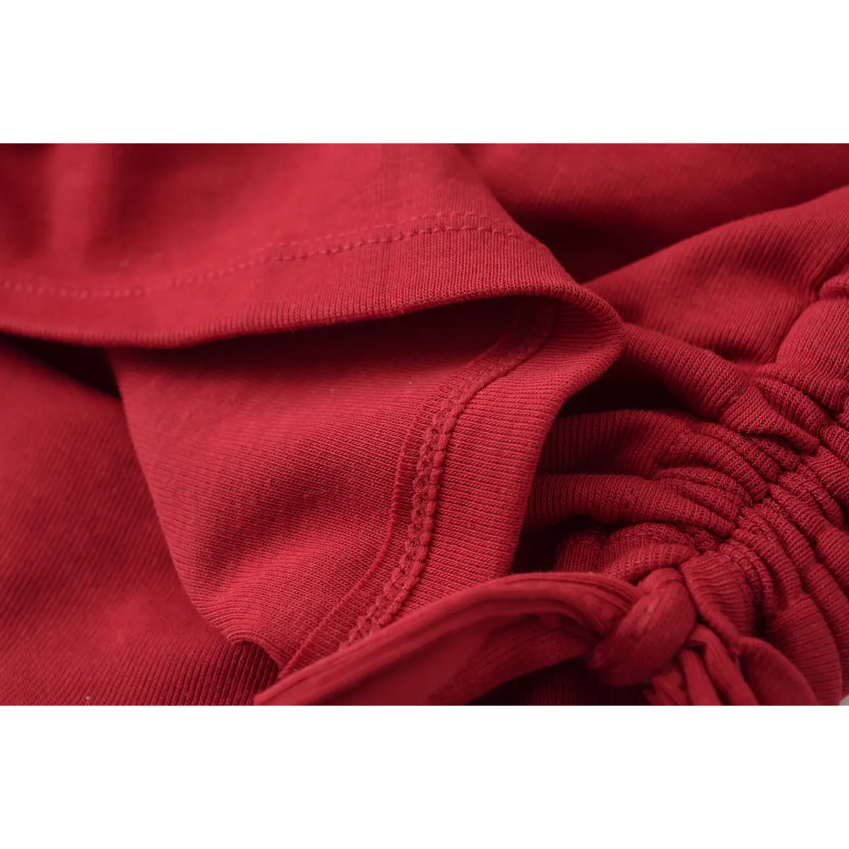 Close-up of the side drawstring ties and gathered ruching on the burgundy halter top.