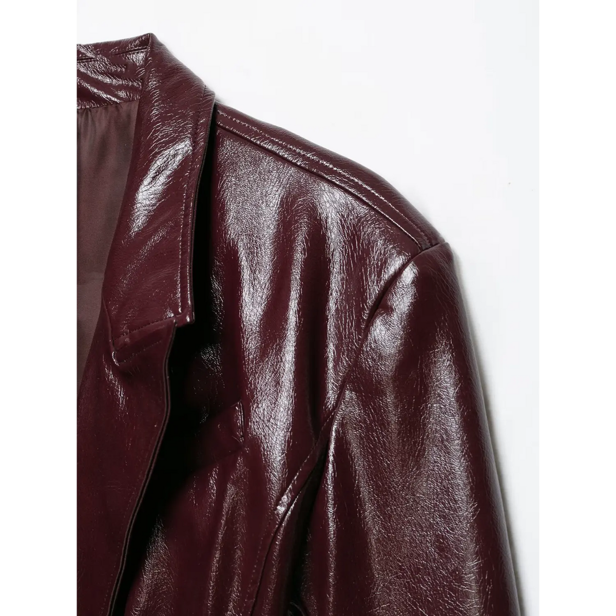 Close-up of shoulder seam on burgundy glossy leather blazer