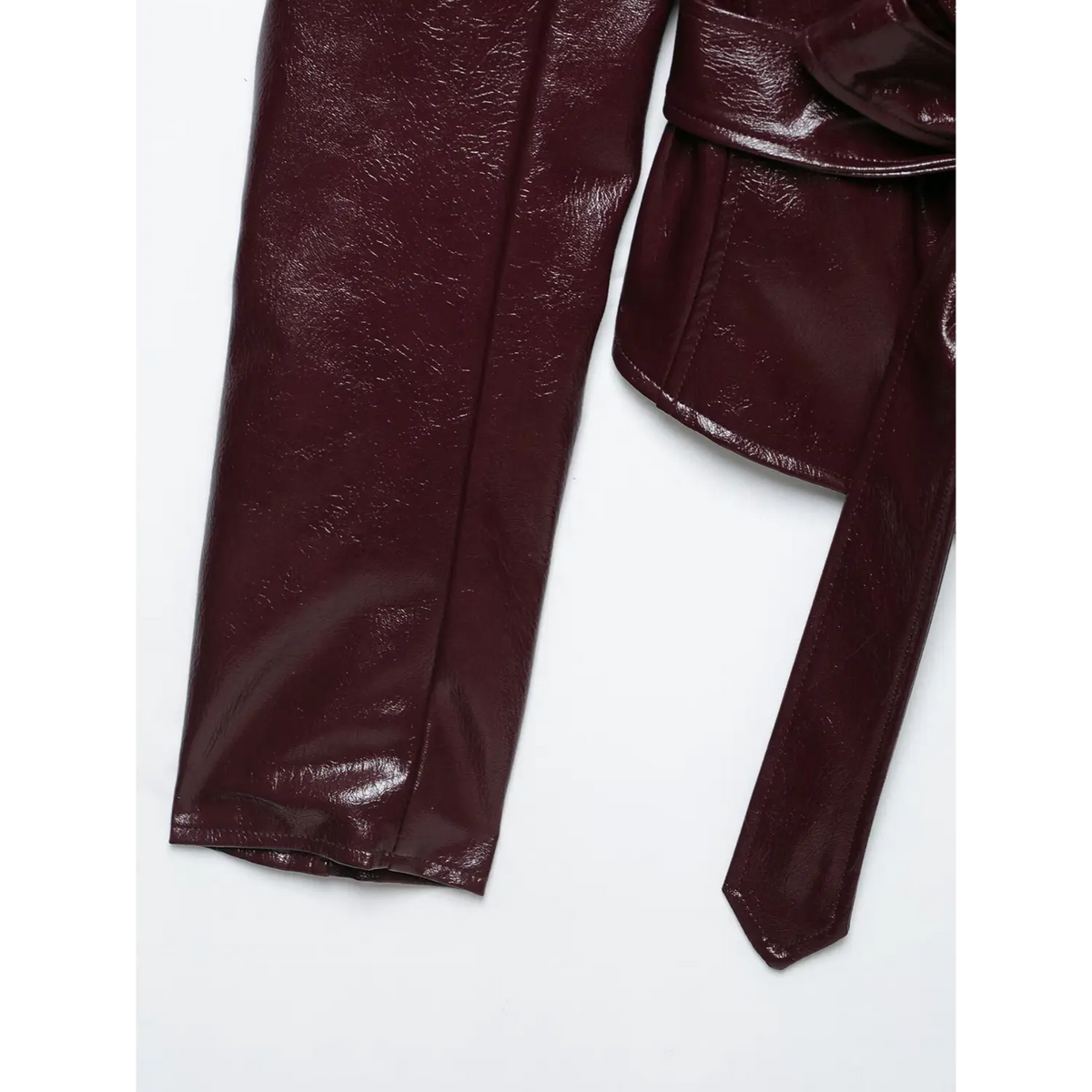 Close-up of long sleeve and belt tie end on burgundy leather blazer