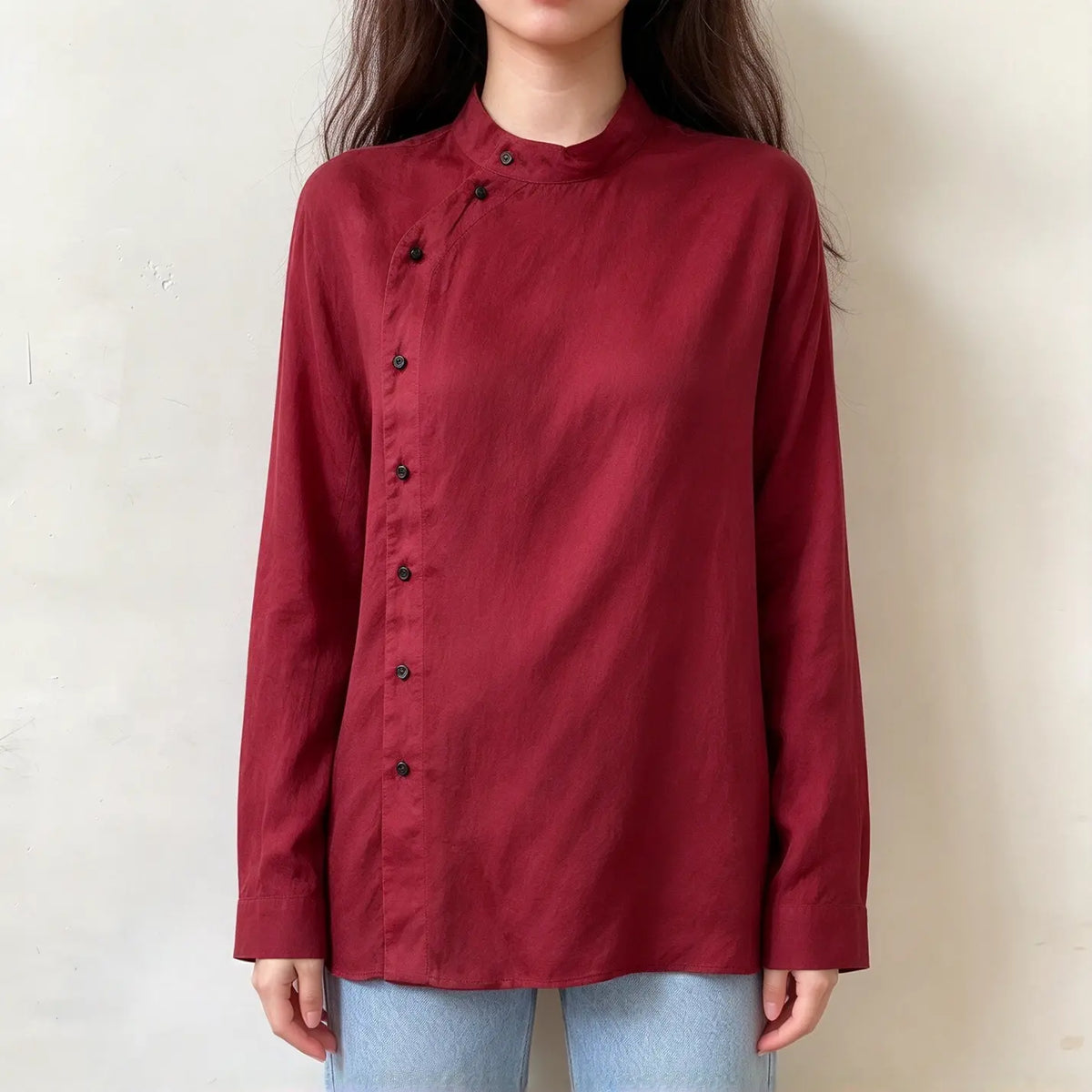 Model wearing burgundy mandarin collar asymmetric button blouse with jeans, front view