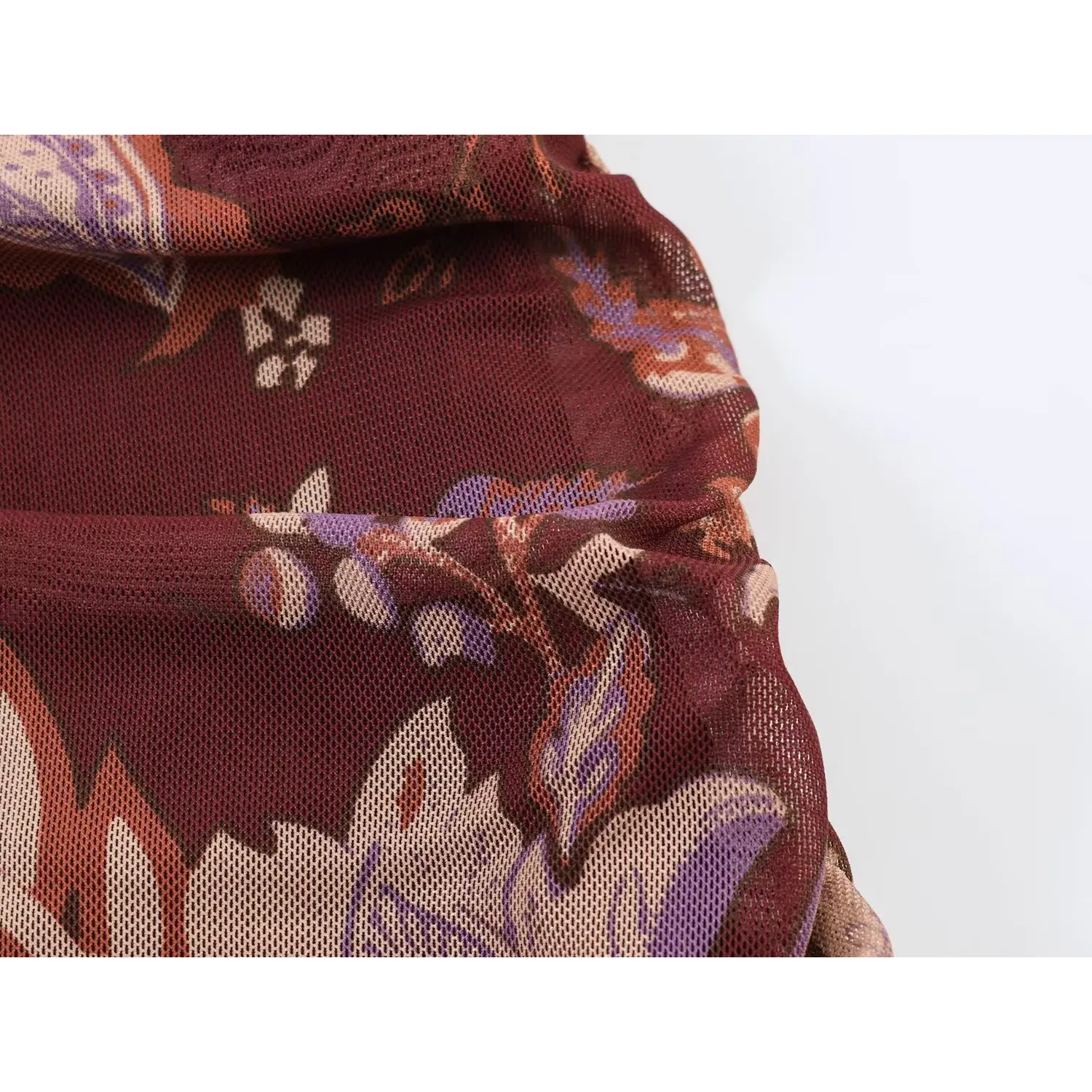 Detailed view of soft stretch mesh fabric texture of burgundy paisley maxi dress
