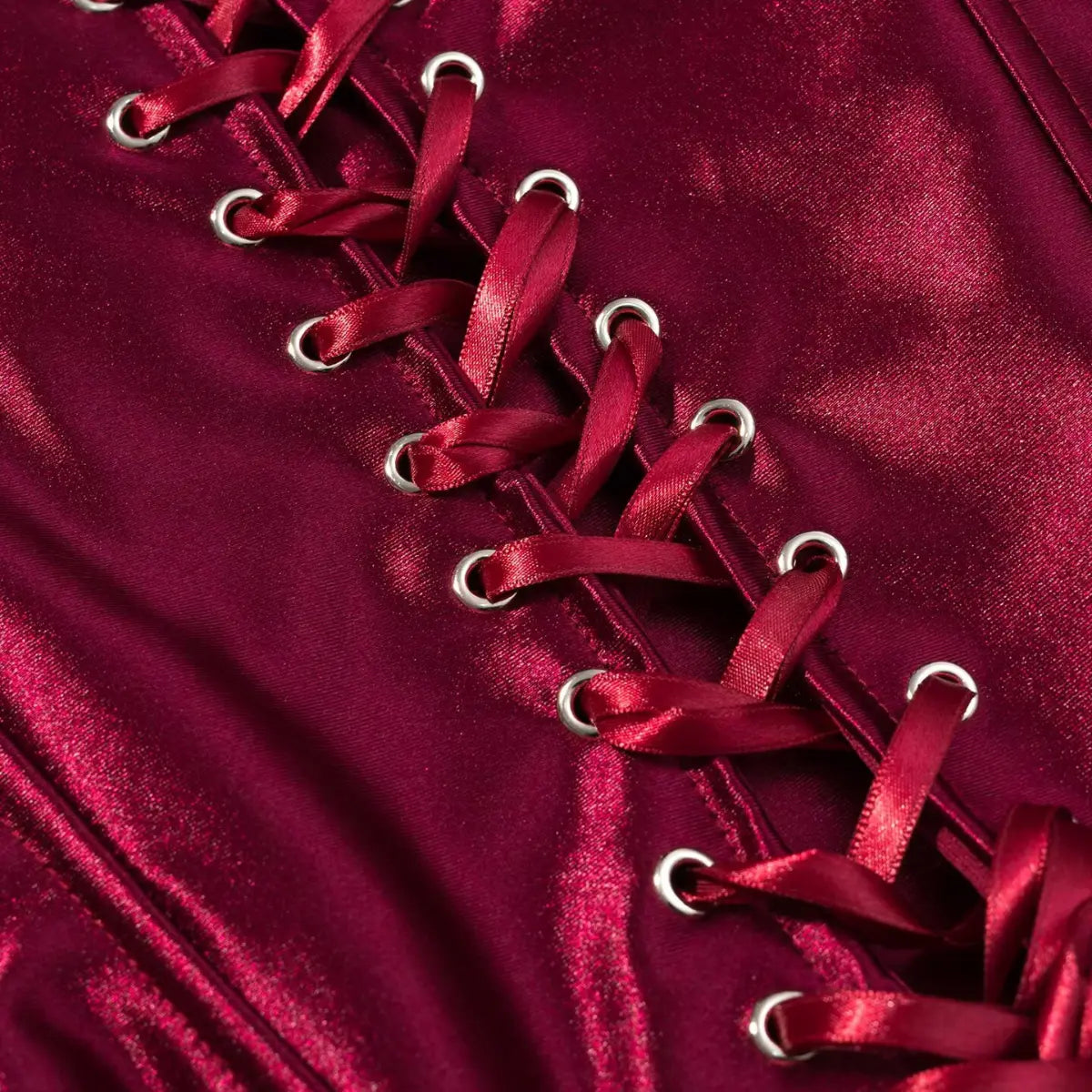 Close-up of the lace-up front on the burgundy metallic corset top, with satin ribbon and eyelets