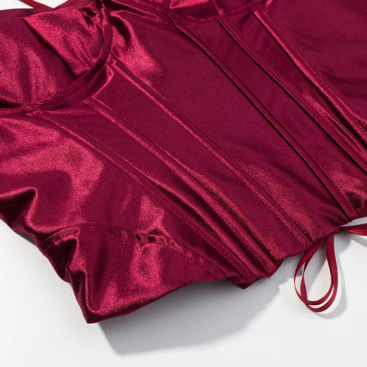 Side view of burgundy metallic corset top, highlighting the vertical boning and fabric sheen