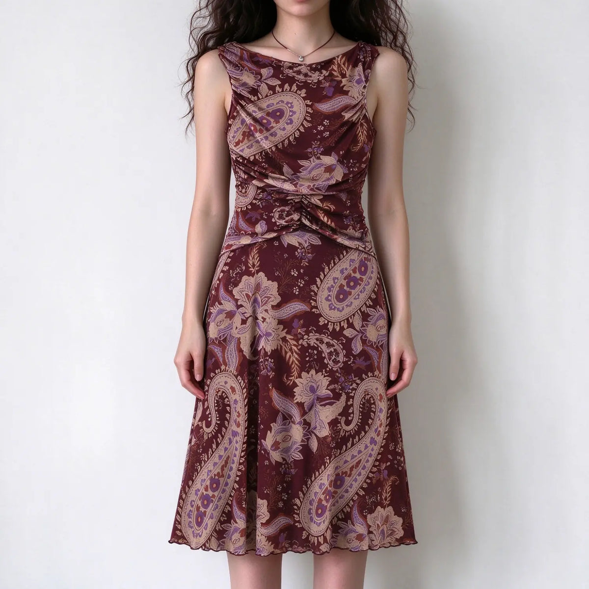 Model wearing burgundy paisley print sleeveless maxi dress with ruched waist and mermaid hem, white background