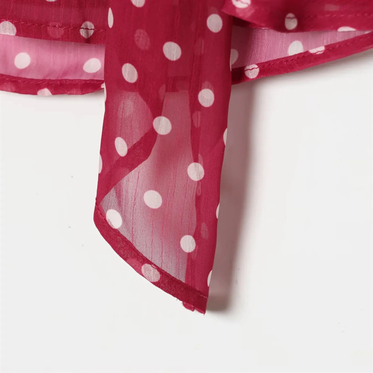 Extended fabric tie tail close-up, pointed hem folded binding stitching, sheer chiffon translucency display
