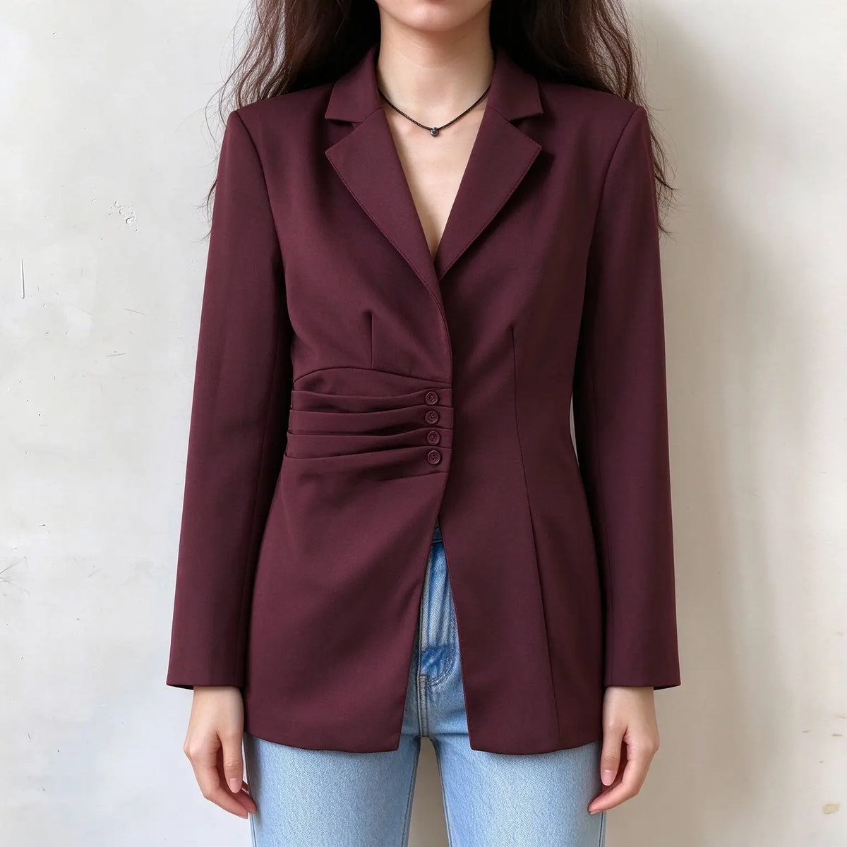 Model wearing burgundy ruched waist notch lapel blazer with jeans, front view
