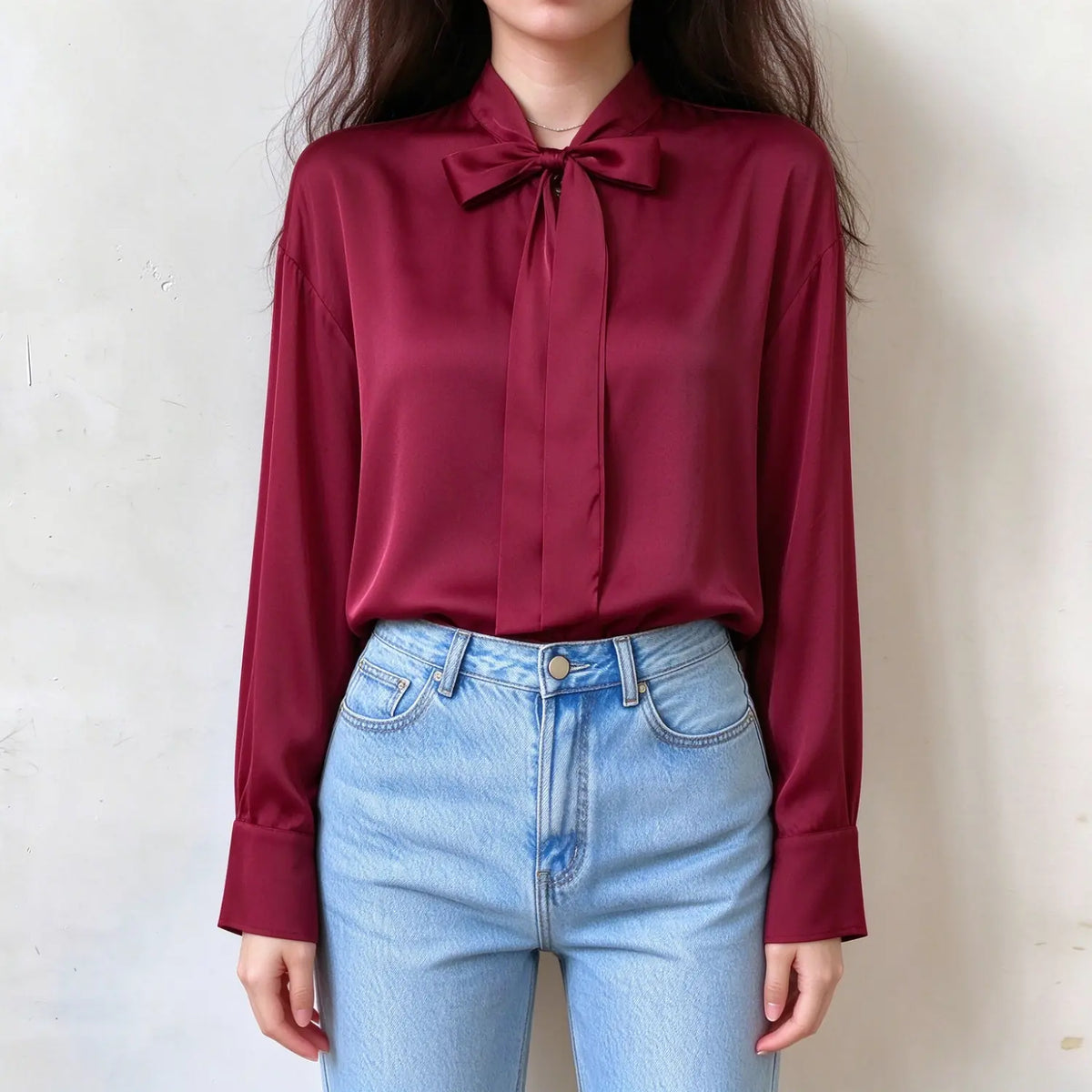 Model wearing burgundy satin blouse, stand collar with front bow tie, long sleeves, smooth shiny satin fabric, relaxed fit