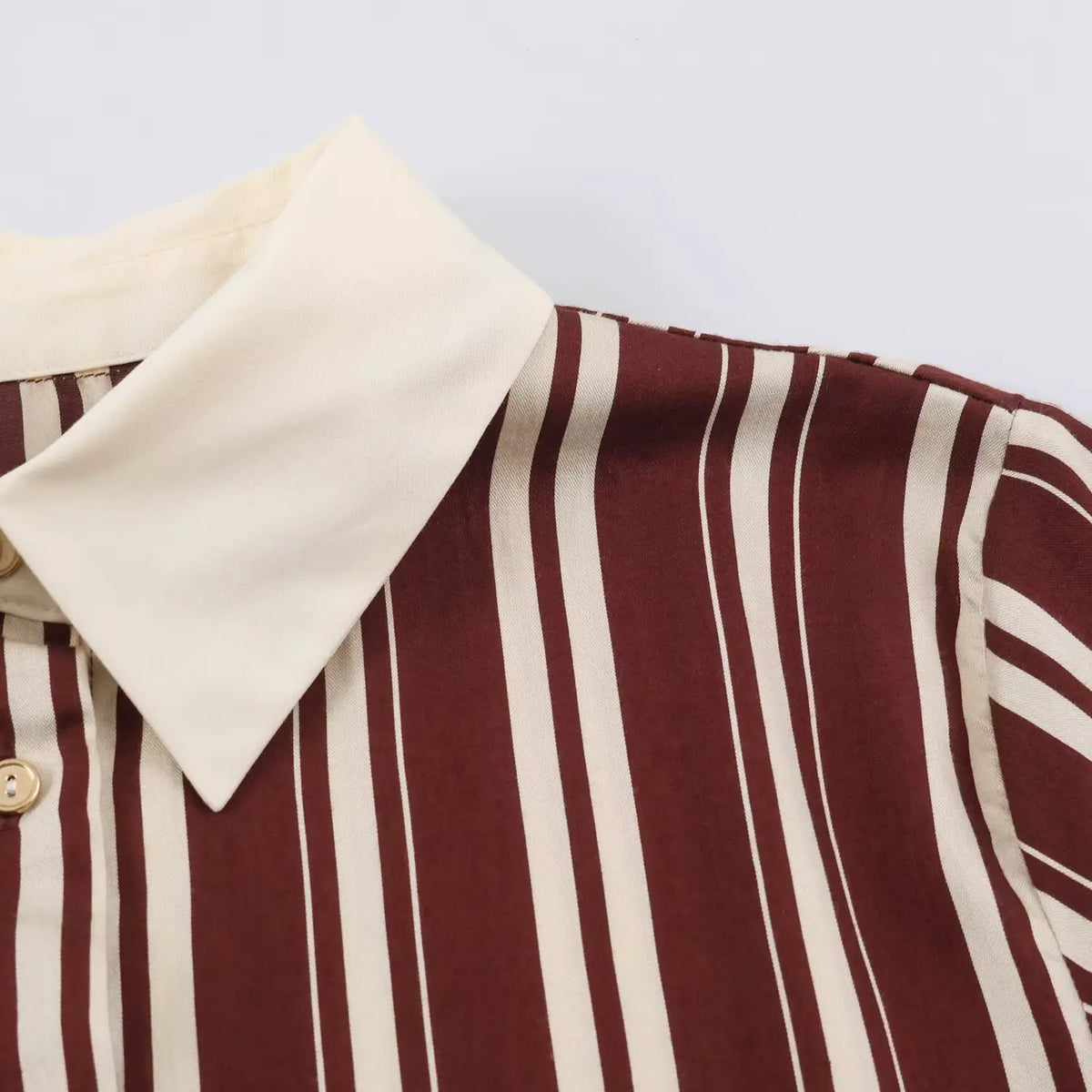 Macro detail of contrast cream collar and burgundy white vertical stripe fabric