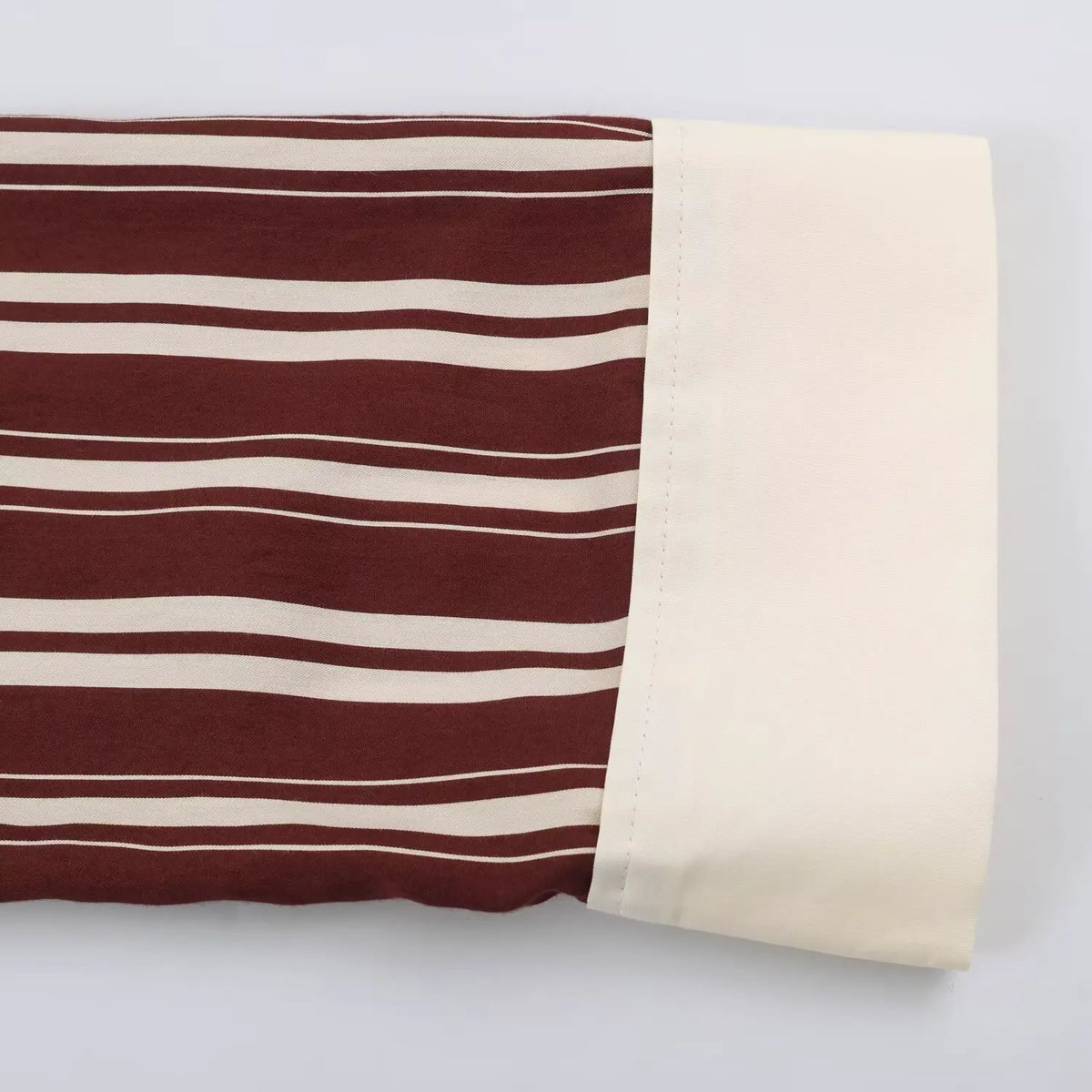 Close‑up of cream contrast cuff on burgundy white vertical stripe shirt maxi dress