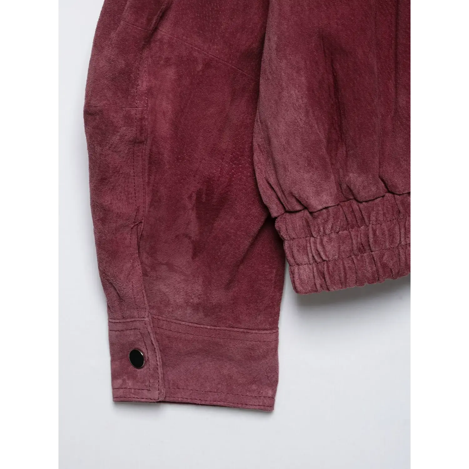 Close-up sleeve cuff with black snap button burgundy suede jacket