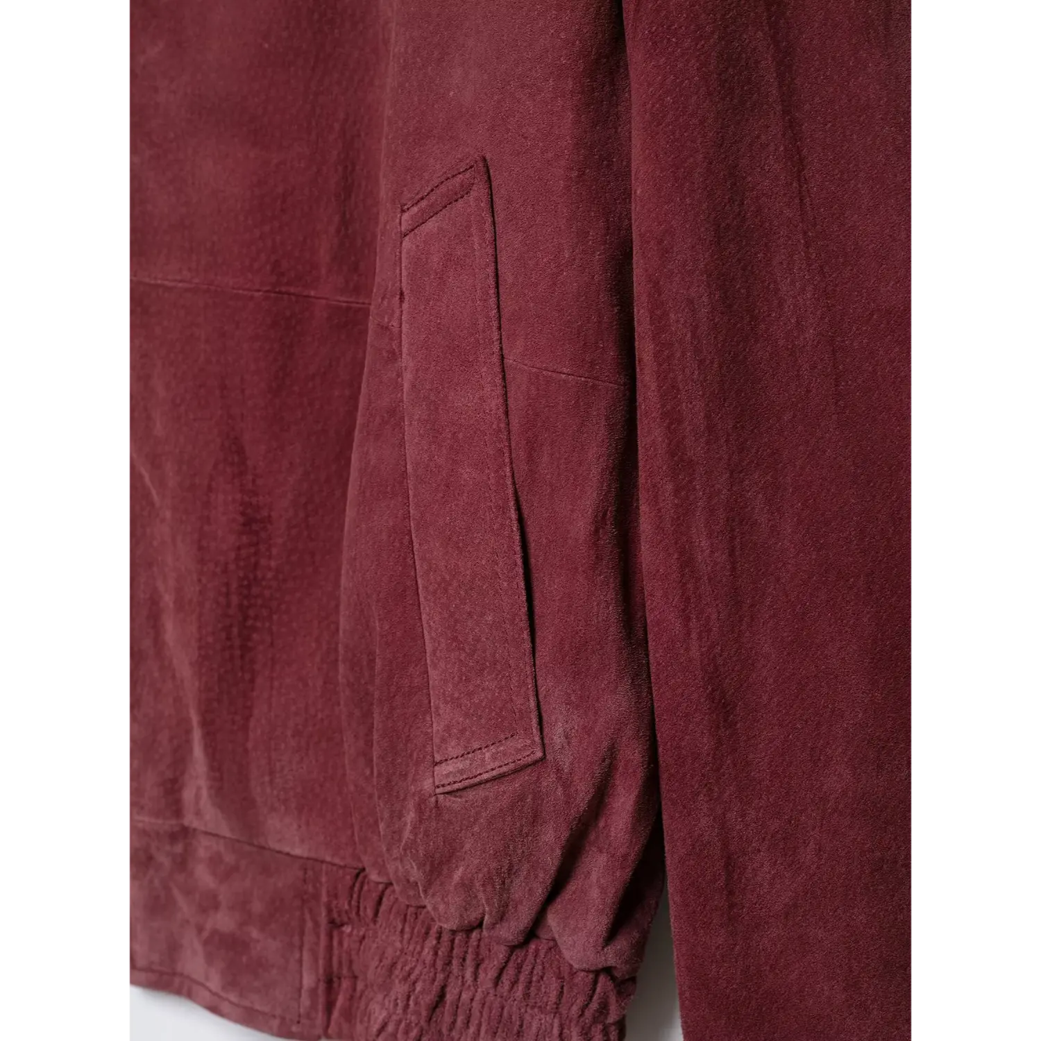 Close-up front patch pocket detail burgundy suede cropped bomber jacket
