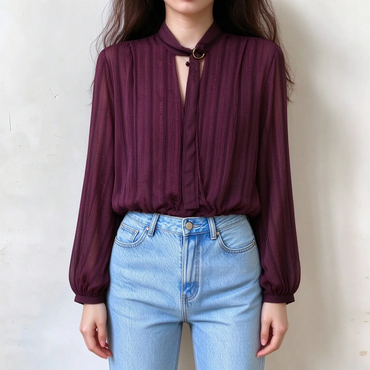 Model wearing burgundy tie neck ring detail blouse, front view