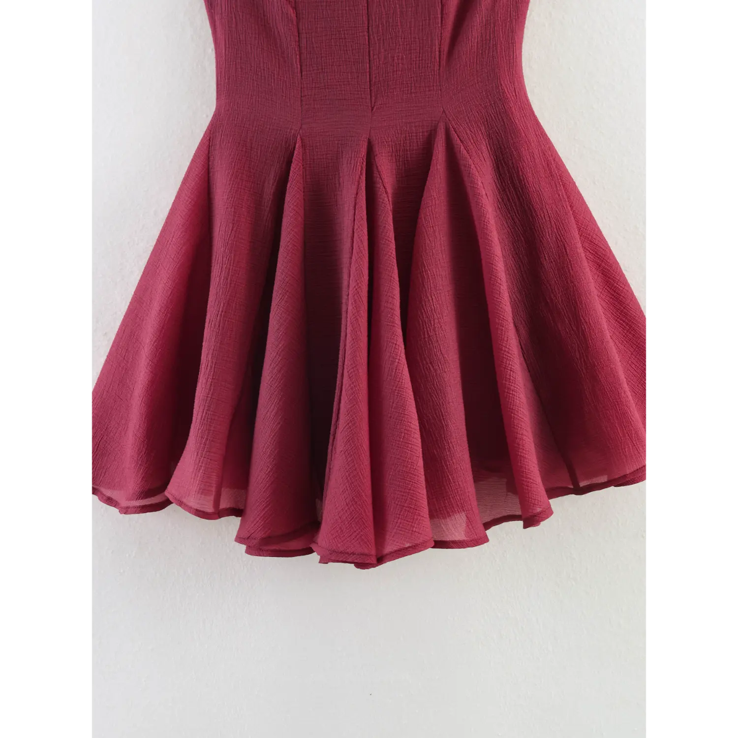 Close-up waist-to-hem partial shot of wine red crinkle textured sleeveless dress skirt, multi-gore radiating panels, double folded ruffle hem, lightweight semi-sheer woven fabric, smooth matching full lining underneath