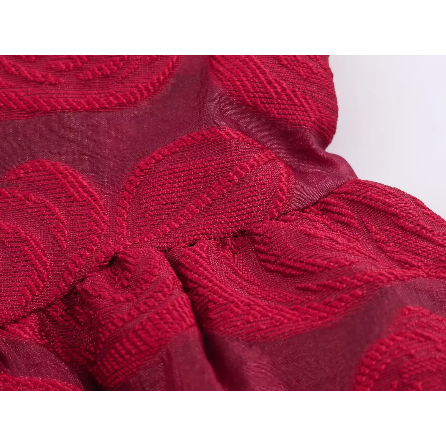 Macro close‑up of burgundy red embossed jacquard fabric texture