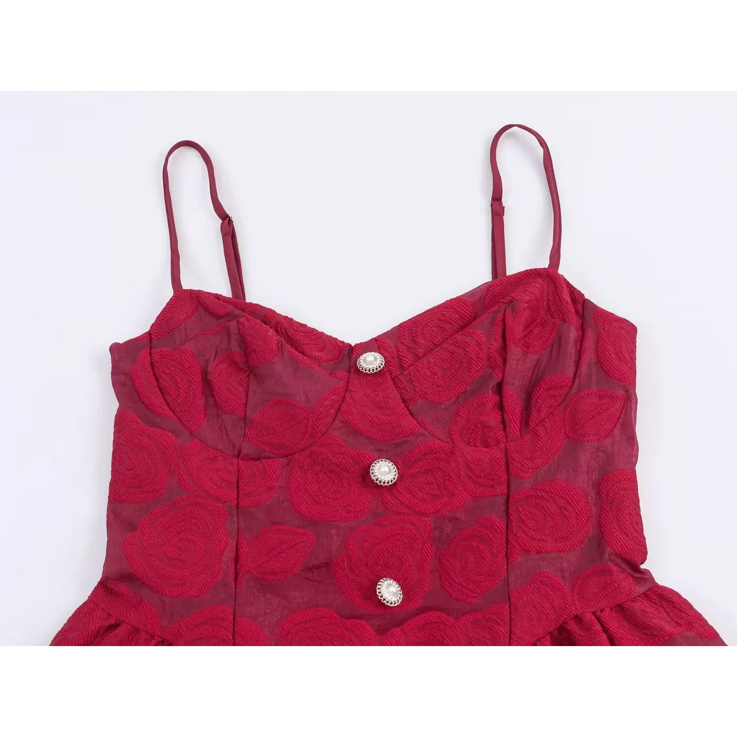 Close‑up of front bodice with spaghetti straps and pearl buttons