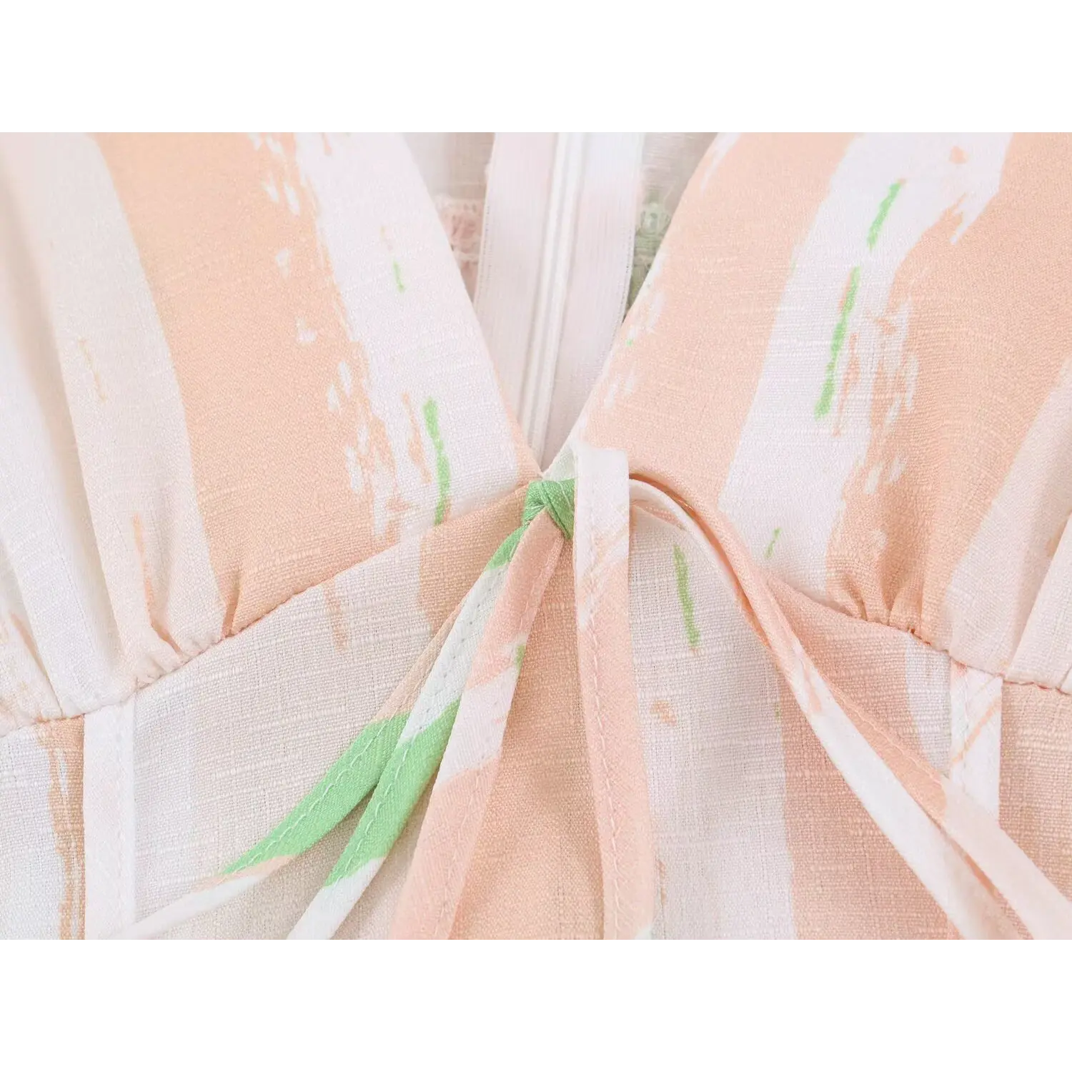 Front bust self fabric tie knot close-up, matching peach green stripe fabric drawstring on v-neck sundress