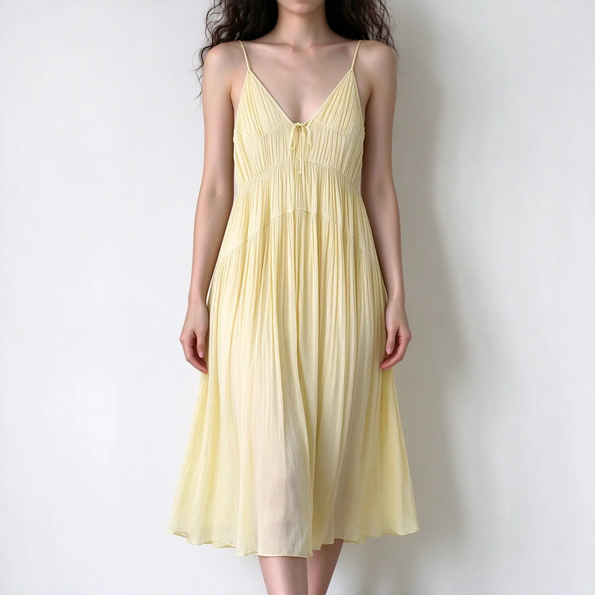 Model wearing butter yellow spaghetti strap maxi dress, v neck, front tie, crinkled flowy fabric, airy swing skirt