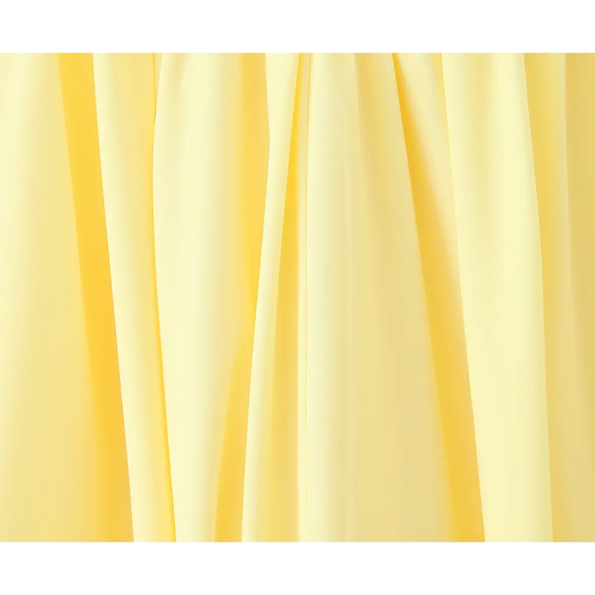 Close-up of the pleated skirt fabric on a butter yellow strapless maxi dress, showing the soft drape and central seam.