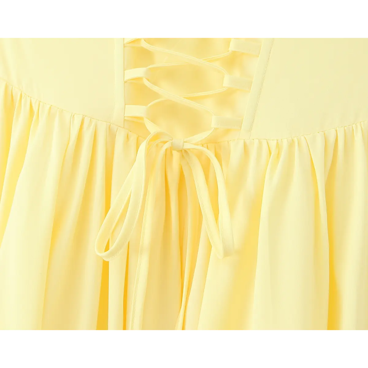 Close-up of the corset lace-up back on a butter yellow strapless dress, featuring a tied bow at the waist.