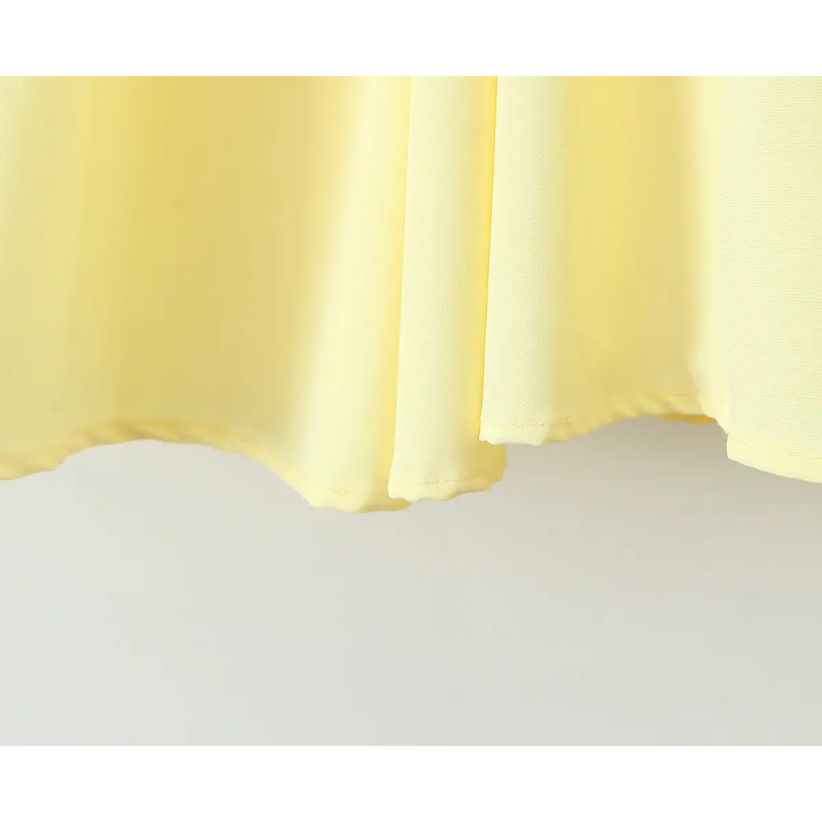 Close-up of the finished hem stitching on a butter yellow strapless maxi dress.