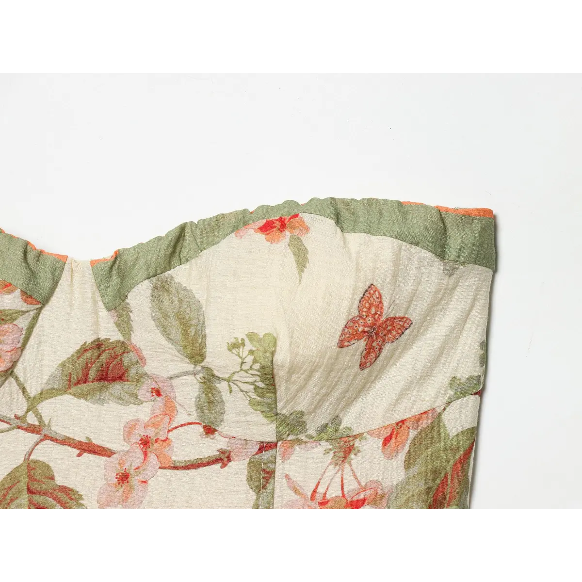 Waist bow detail of cottagecore sundress, wide matching printed belt knotted into big side bow with green piped edge finishing.