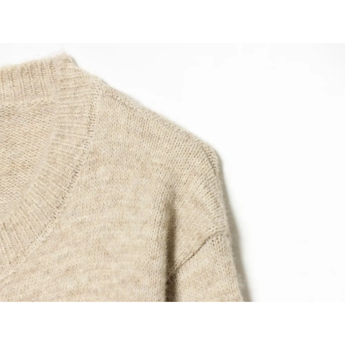Shoulder close-up of cable knit capelet, oatmeal soft fuzzy knit texture