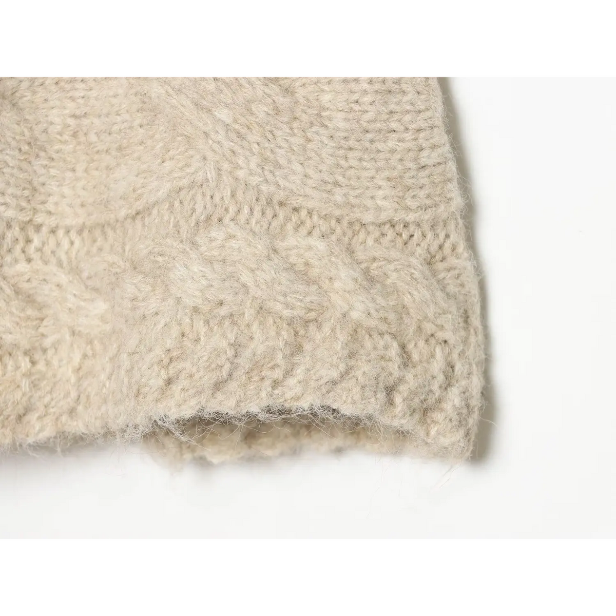 Close-up hem texture of oat cable knit mini skort, fuzzy knit fabric scalloped edge