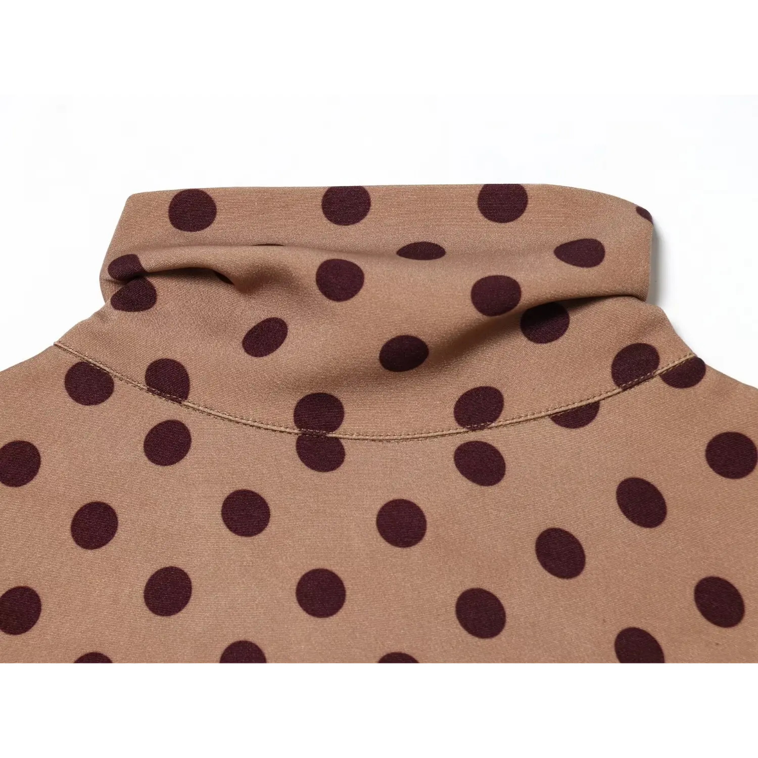 Close-up macro view of folded turtleneck neckline on camel dark polka dot sleeveless midi dress