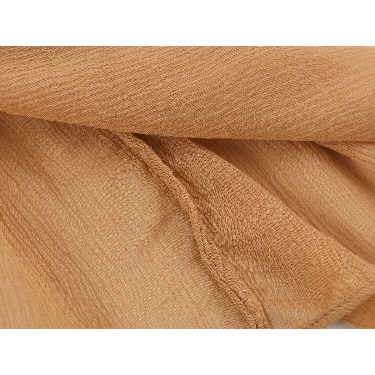 Close‑up of layered crinkled chiffon fabric and finished stitching seam