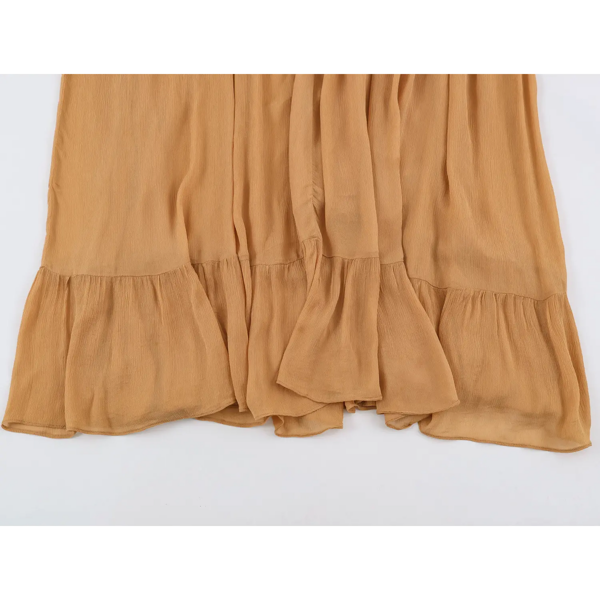 Flat lay view of flowy ruffled tiered skirt hem of camel maxi dress