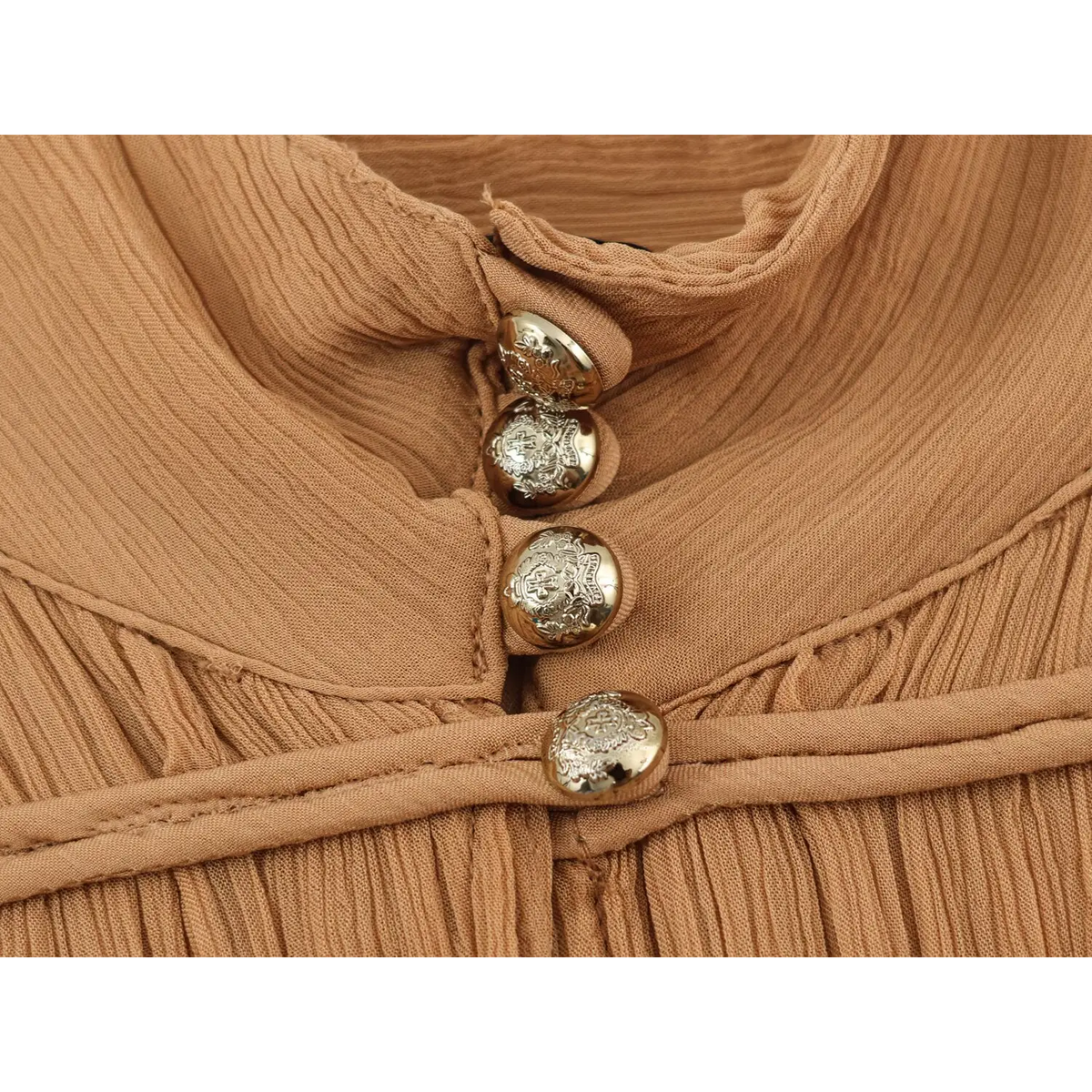 Close‑up view of camel dress stand collar with engraved metallic buttons