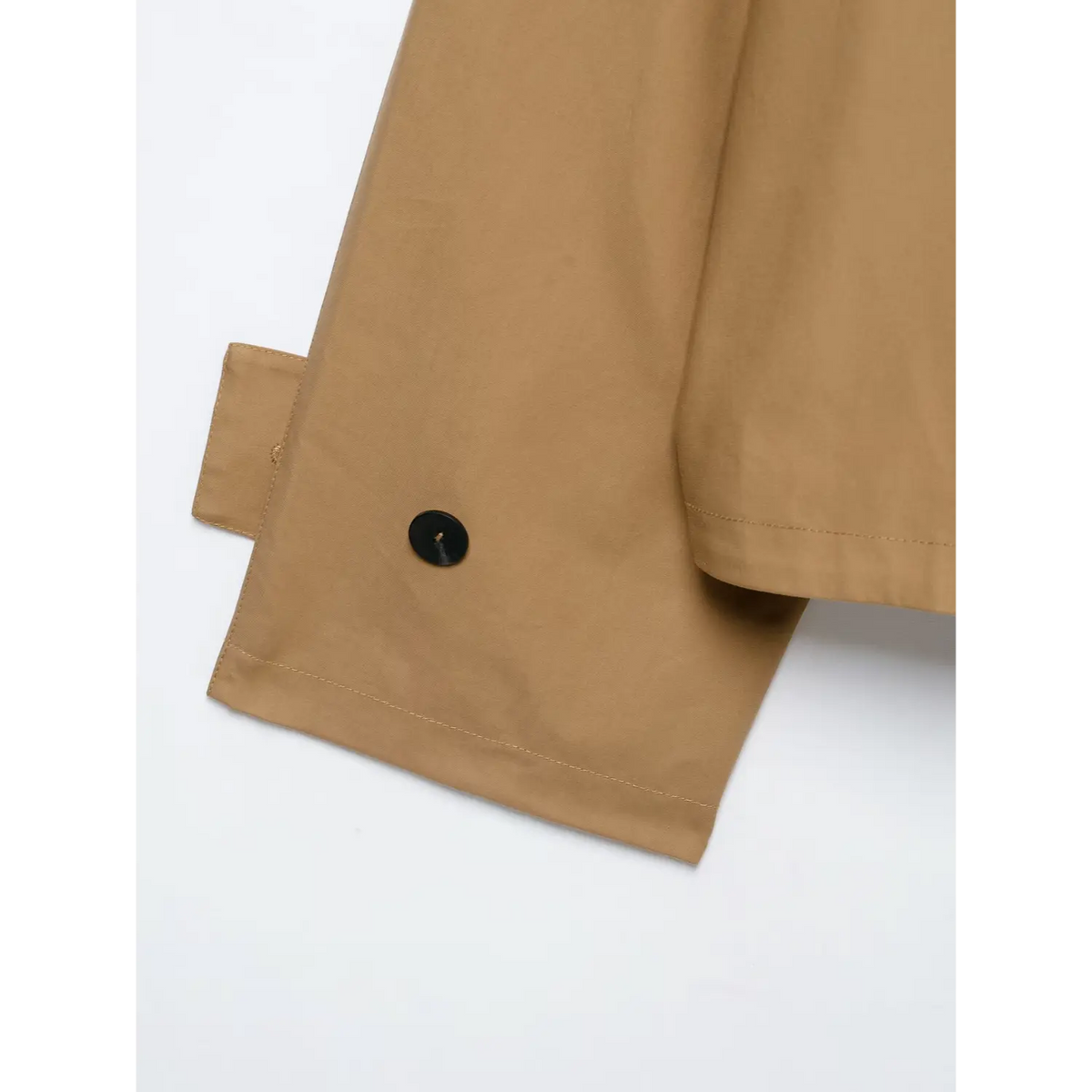 Side partial shot of camel jacket sleeve cuff, black decorative button and folded tab design