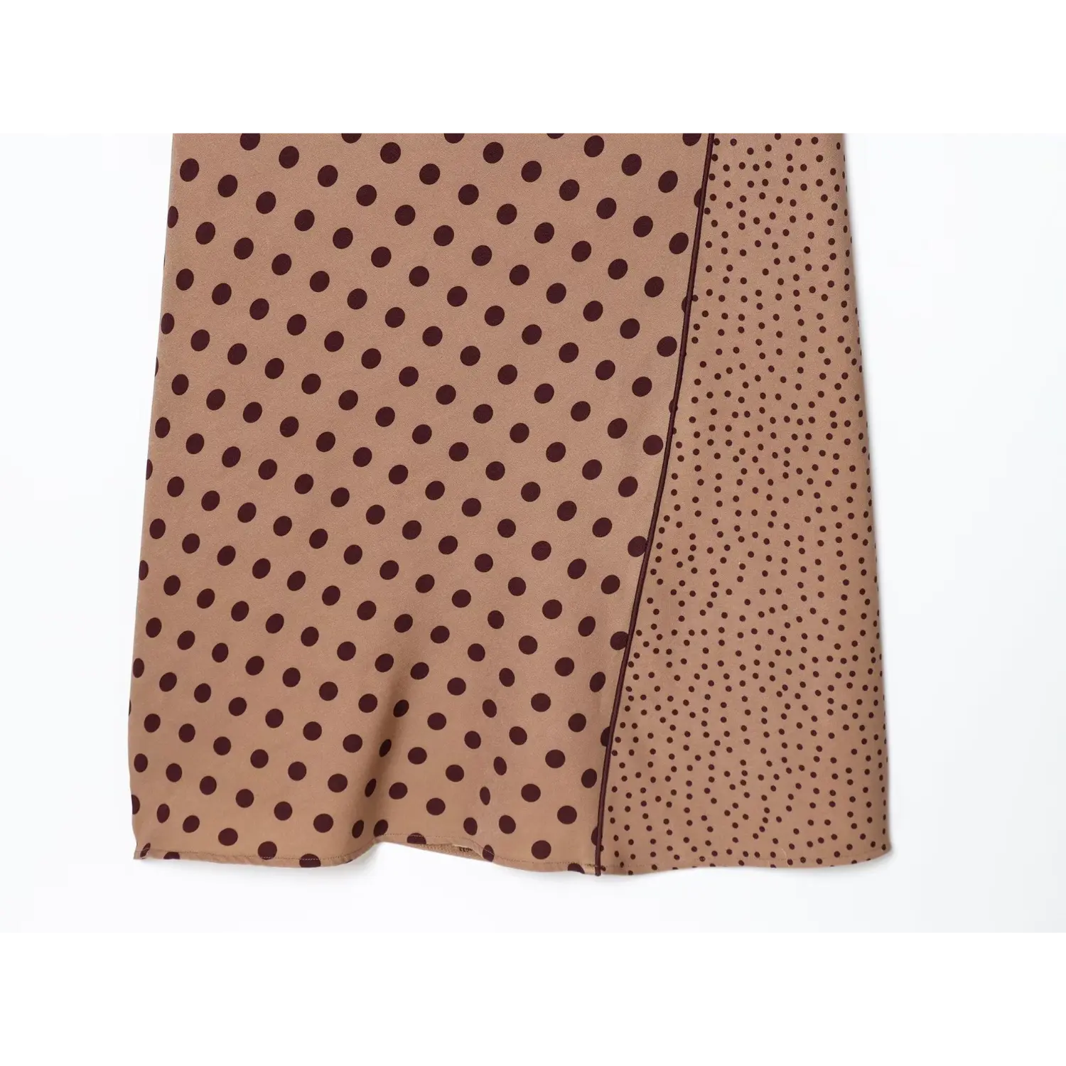Flat close-up of skirt hem with mixed size dark polka dot splicing on camel brown sleeveless midi dress