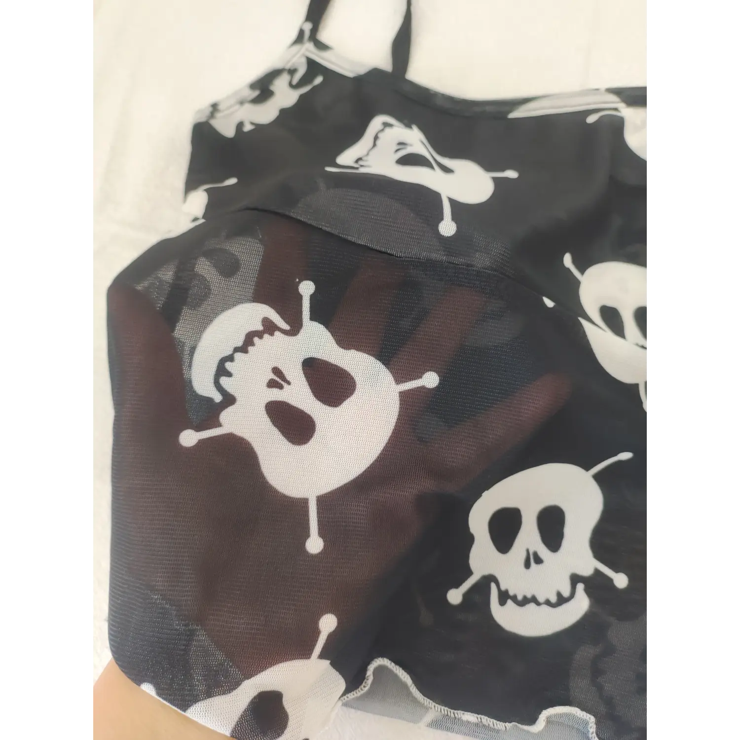 Partial shot of skull mesh camisole, front horizontal seam, semi-transparent black mesh and skull pattern detail