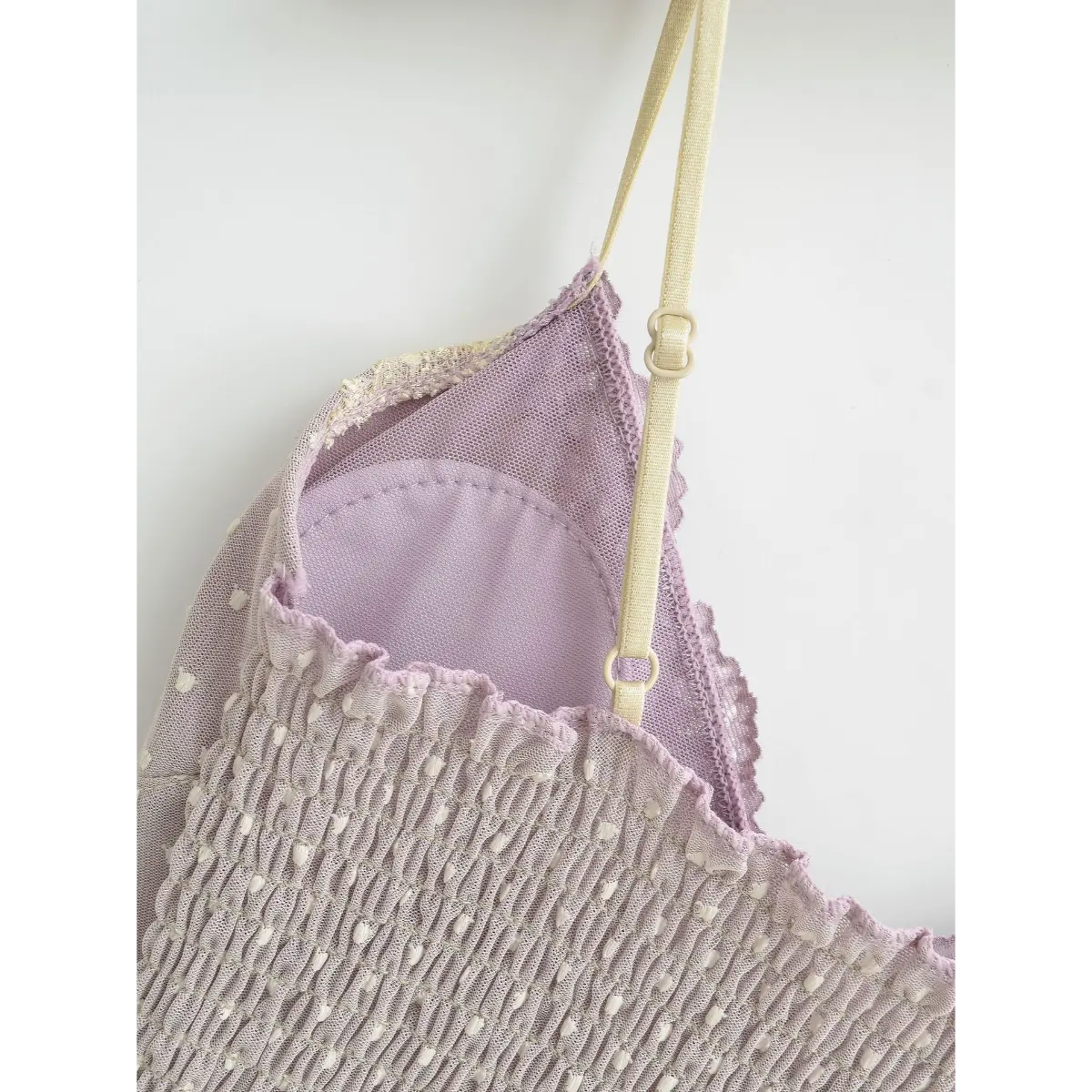 Close-up of the adjustable strap, smocked back panel, and built-in bra lining on a lavender camisole.