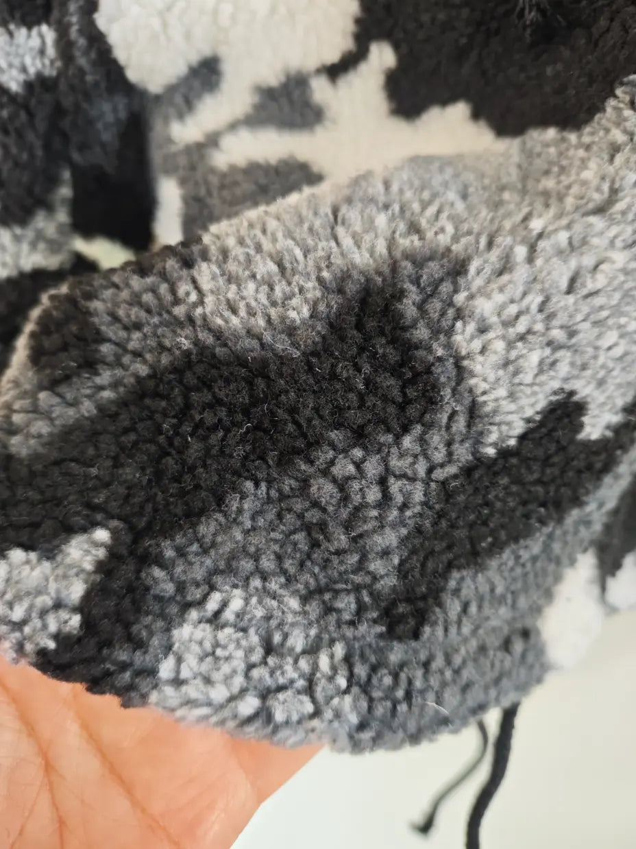 Macro close-up of black grey white camouflage teddy fleece texture