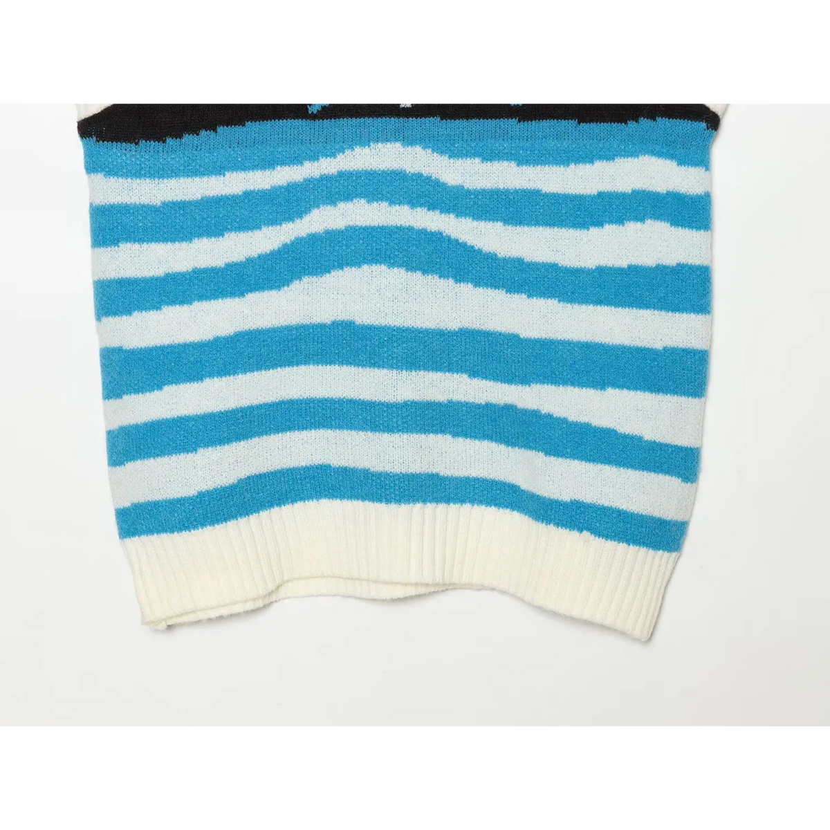 Close-up of blue and white wavy stripe and cream ribbed hem
