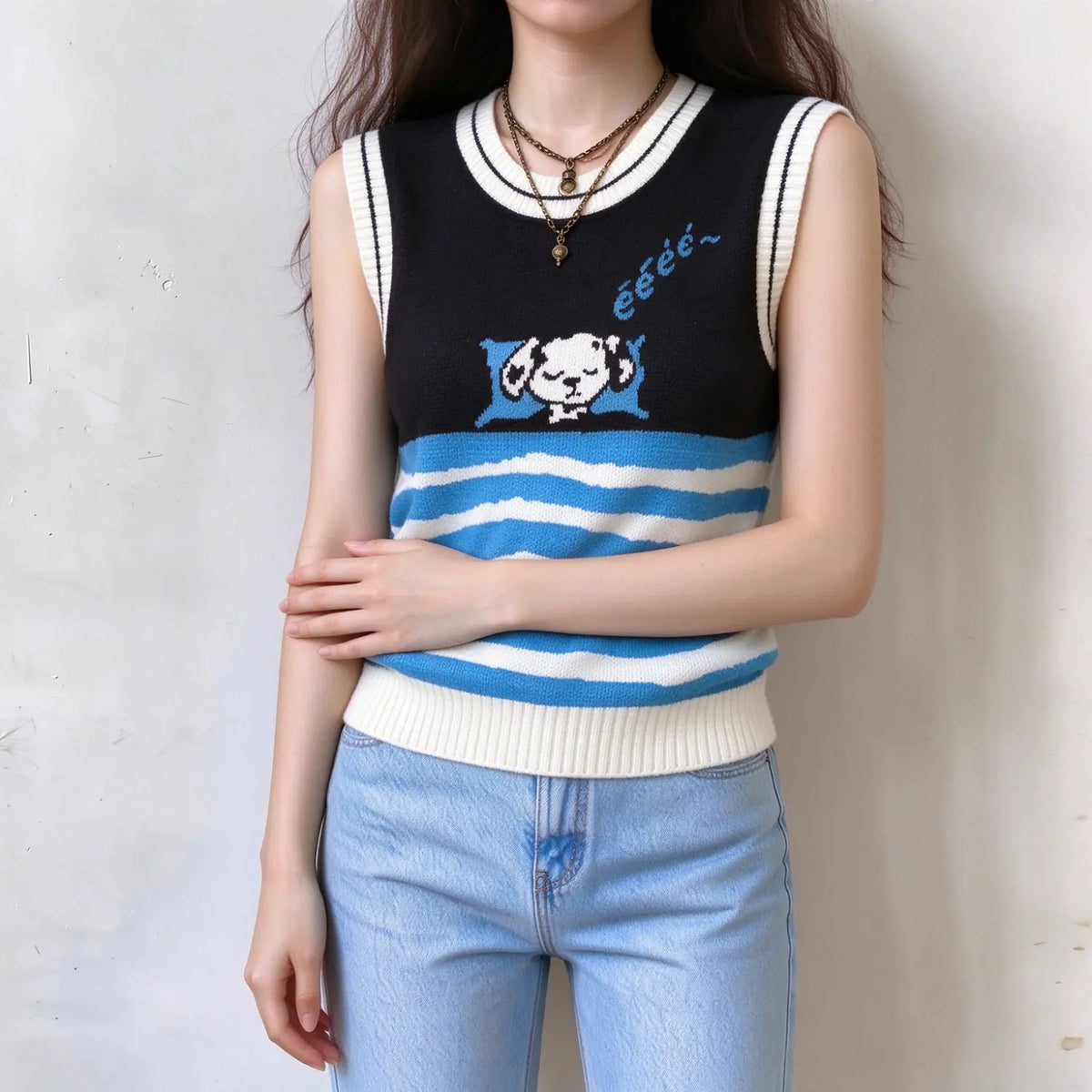 Female model in cute dog pattern knit tank vest, black and blue white wavy stripe design, round neck with contrast piping, model with crossed arms to show casual wearing effect