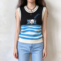 Female model wears sleeveless knit vest, black top with cute sleeping cartoon dog graphic, blue and white wavy stripe hem, white trim on crew neck and armholes, front full torso shot