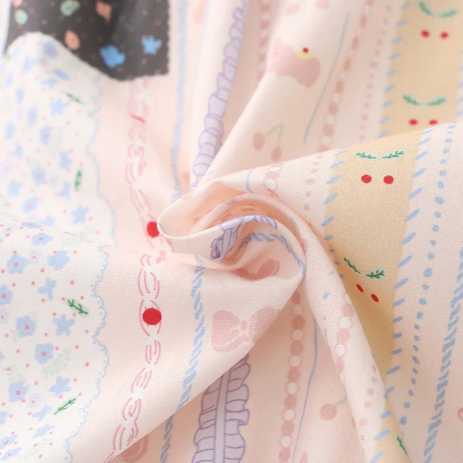 Cartoon print cotton fabric wrinkle texture macro close-up, clear vertical segmented print pattern lightweight washed cotton natural soft crease breathable skin-friendly fabric touch detail shot