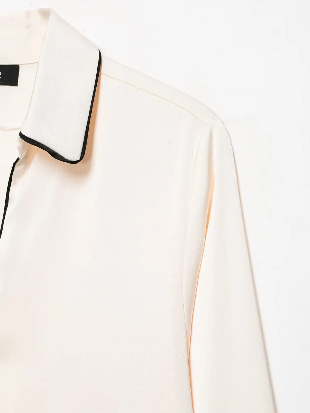 Close-up of black contrast piping on collar edge