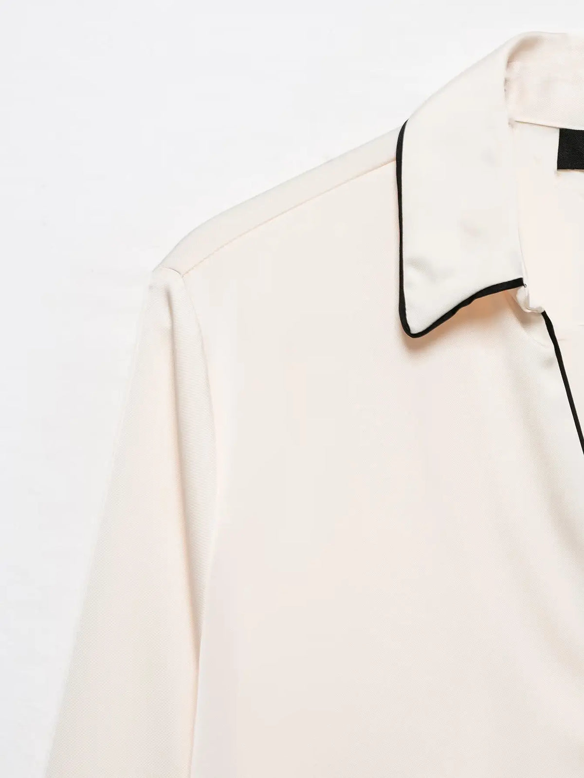 Close-up of shoulder and black contrast piping collar