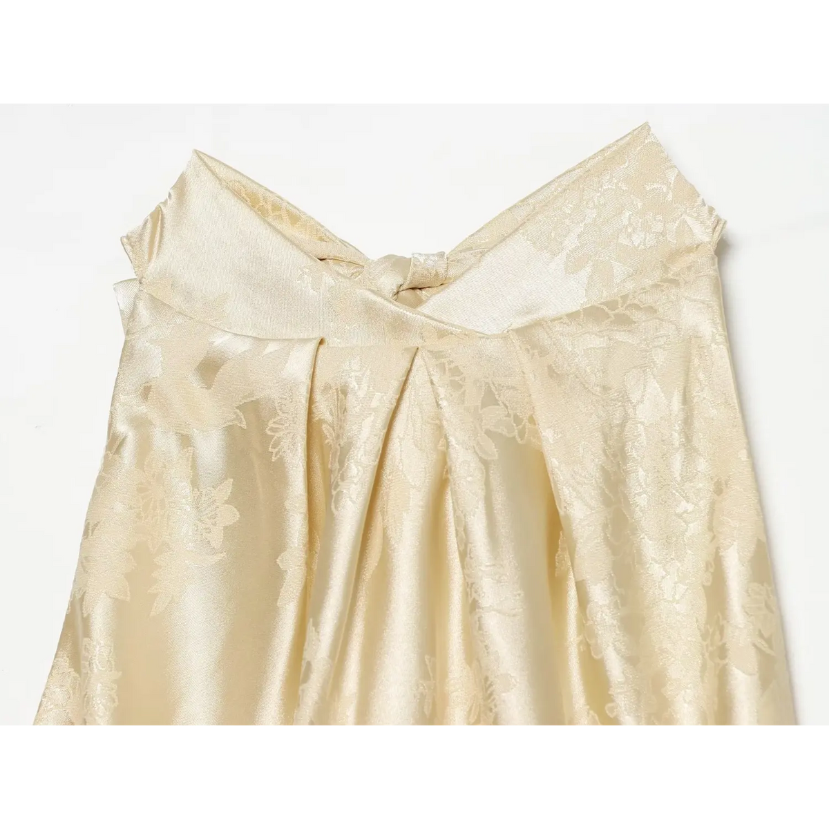 Close-up of draped gathered neckline detail on champagne satin dress